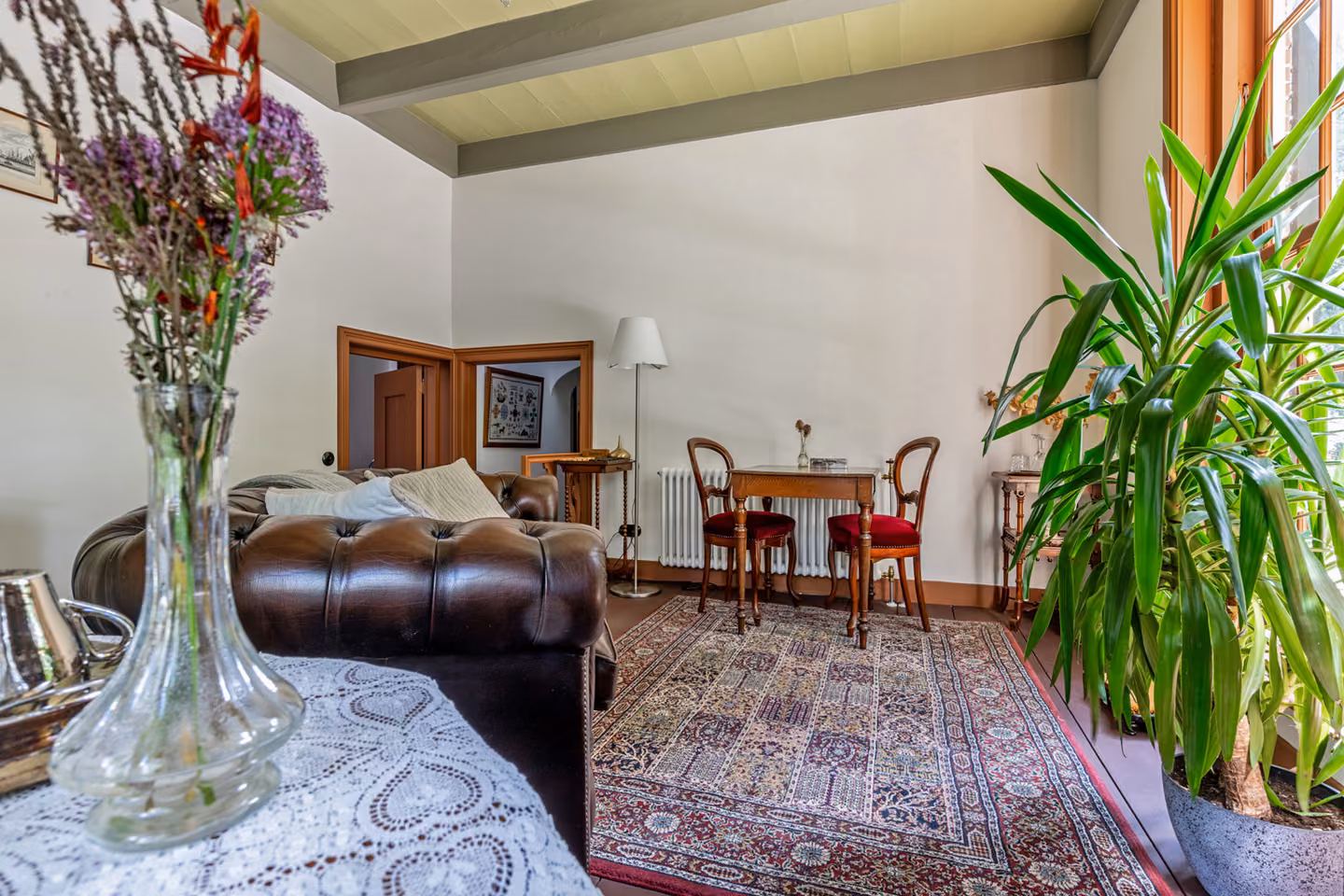 De gedekte ontbijttafel met kanten kleed in de woonkamer