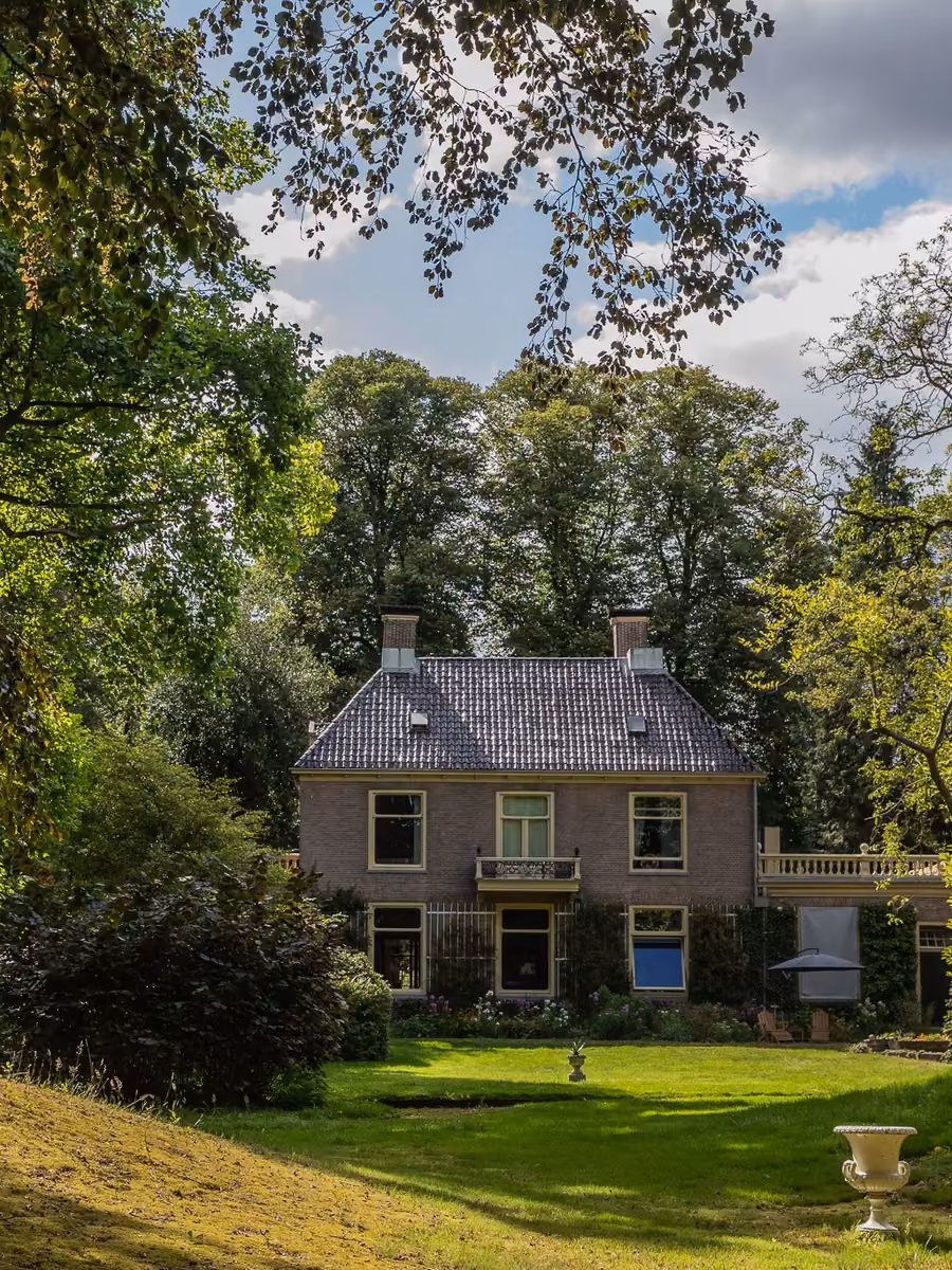 Het gazon van de landschapstuin met Huis Overcingel op de achtergrond