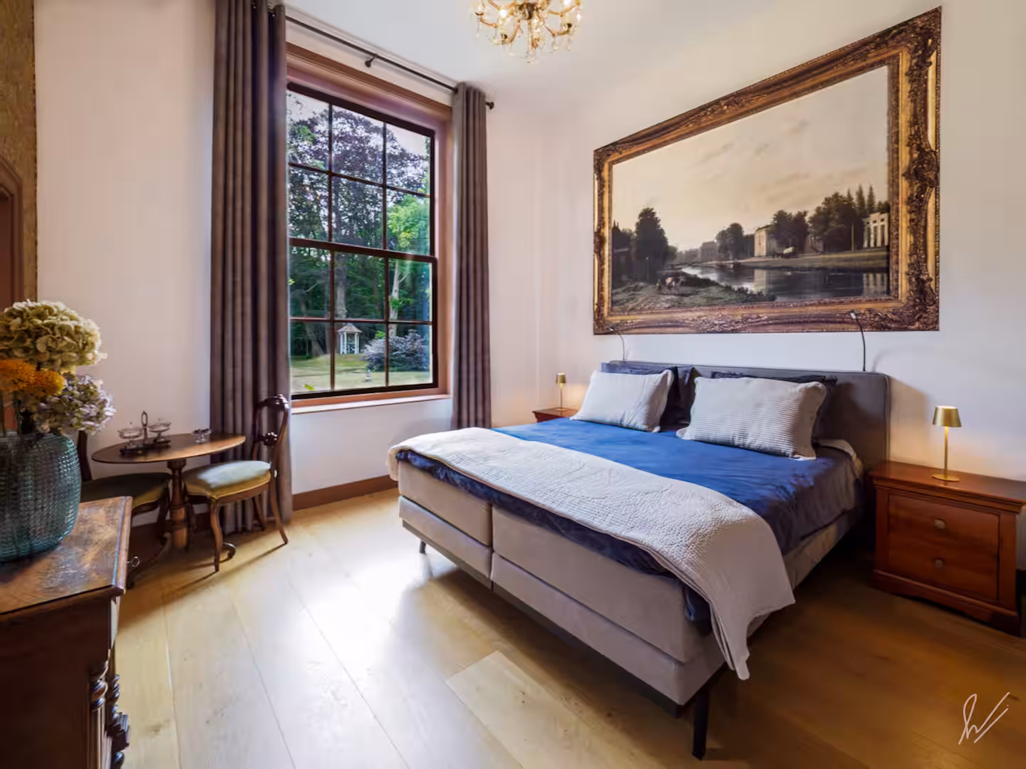 De slaapkamer met kroonluchter en uitzicht op de tuin van Huis Overcingel
