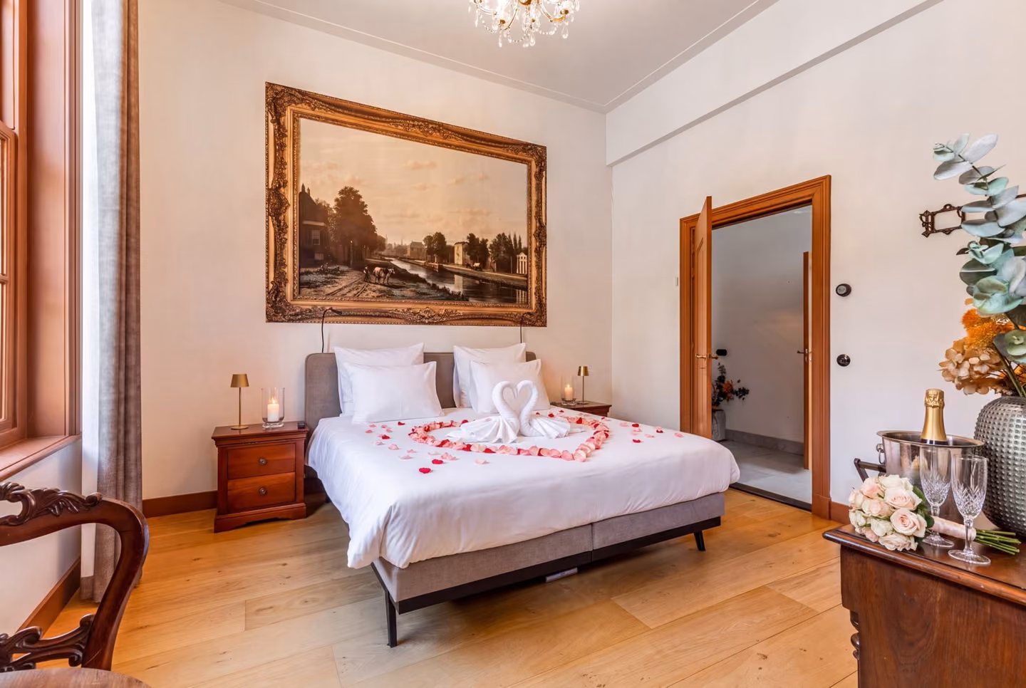 De B&B-suite als bruidssuite, met een hart van rozenblaadjes op het bed en champagne
