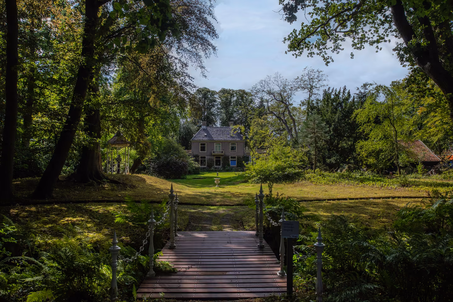 Witte brug in de tuin van Huis Overcingel, met het huis op de achtergrond