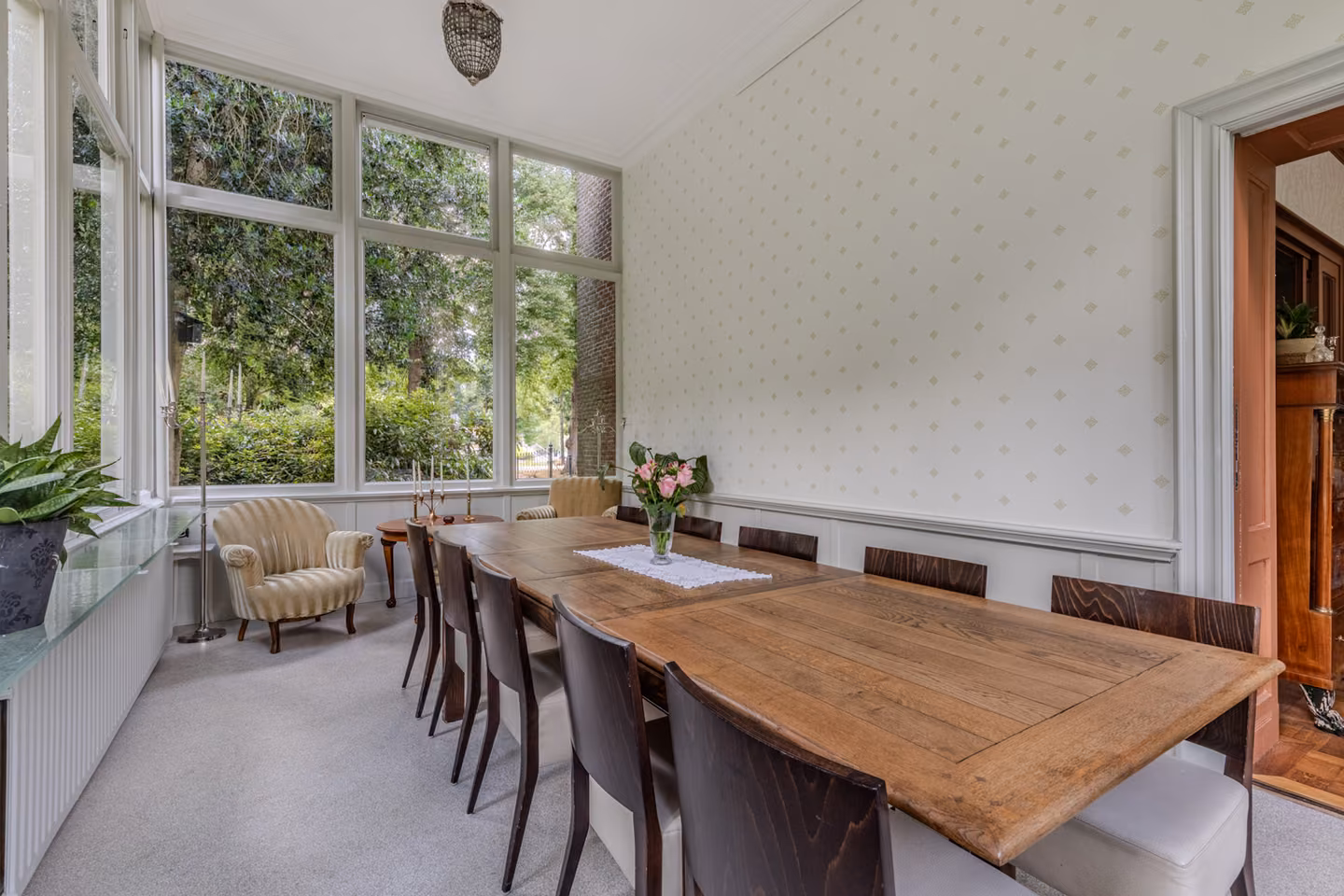 Lange houten vergadertafel in de lichte tuinkamer van Huis Overcingel